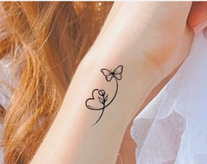 Beautiful butterfly with heart tattoo on a girls wrist