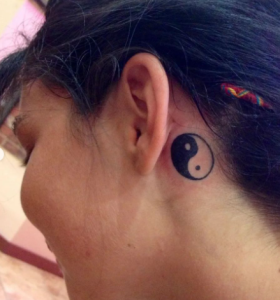 girl with tattoo behind the ear on neck