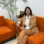 A beautiful young lady in office attires seating on sofa in office, inner plants