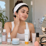 Woman applying moisturiser during skin prep before makeup for oily skin